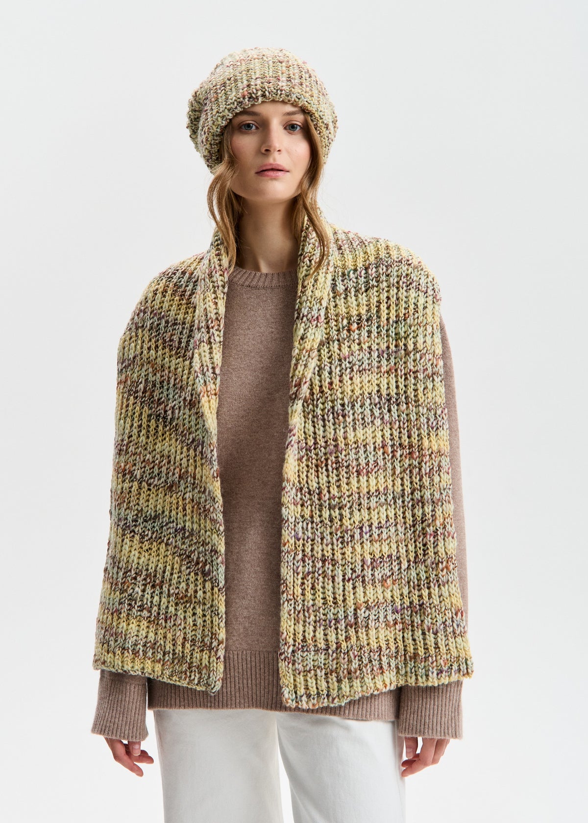 BRIKOLY London Yellow knit beanie worn by a model with a matching scarf draped down the front.