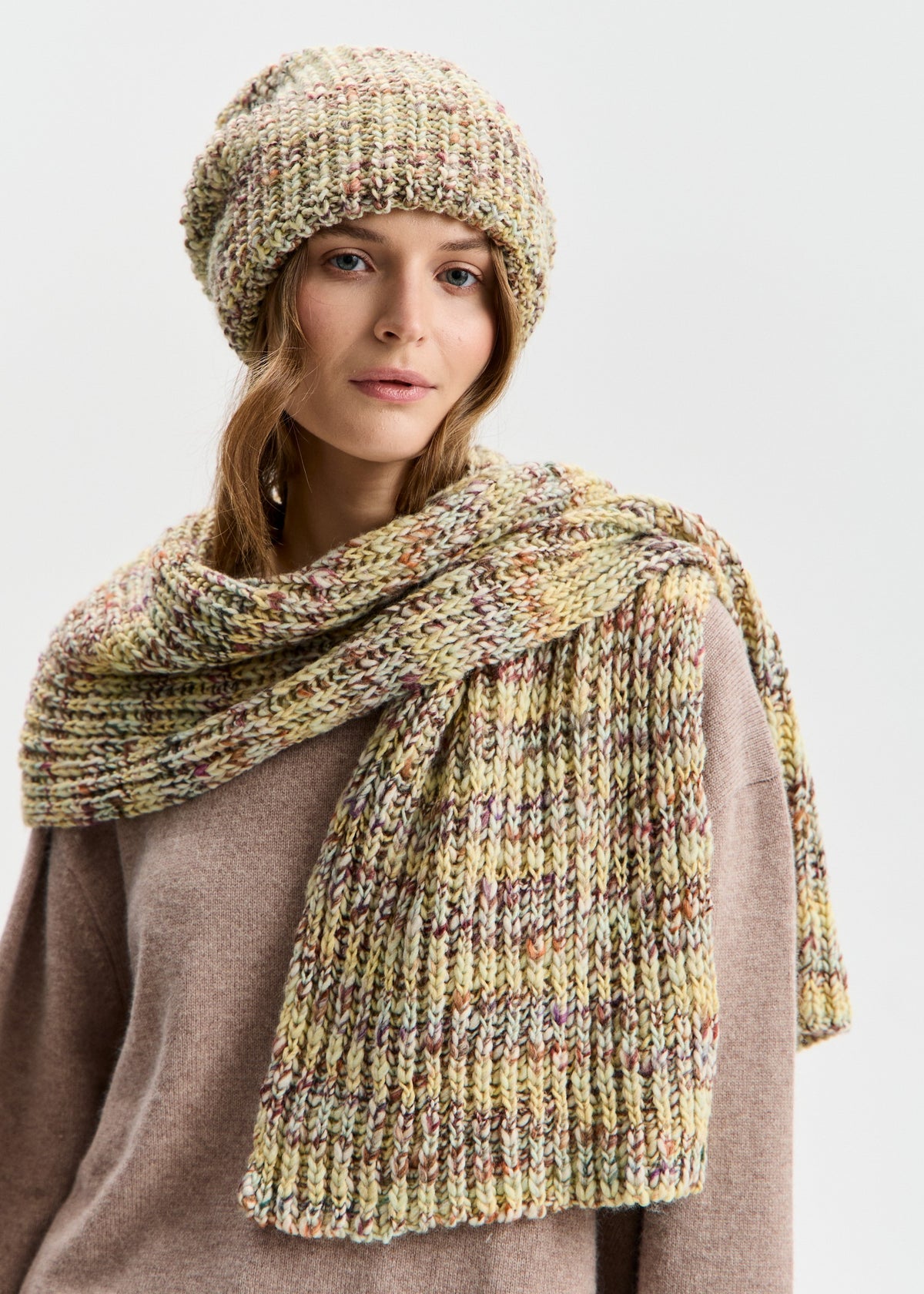 BRIKOLY London Yellow knit beanie shown with a matching scarf wrapped around a model's shoulders.