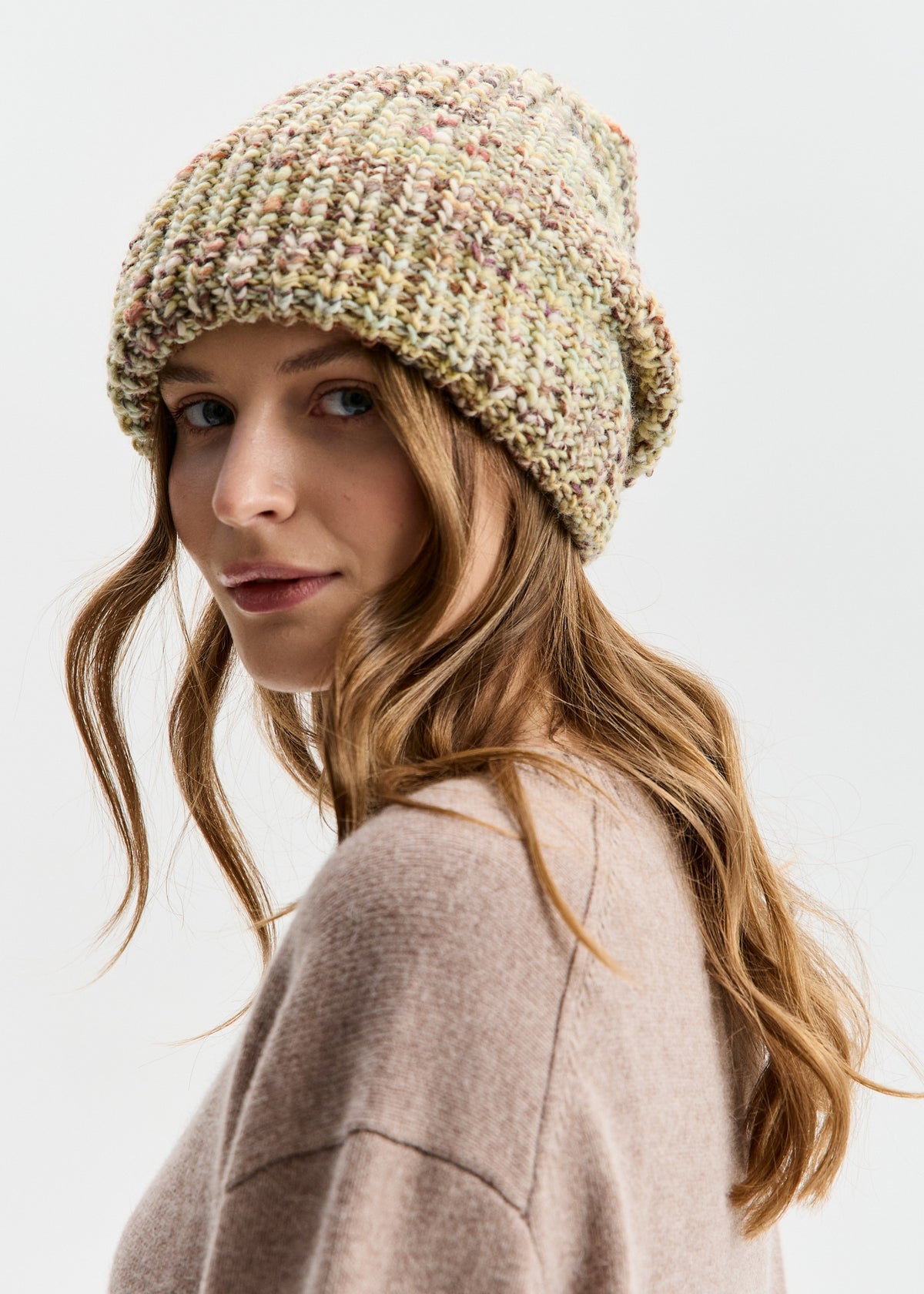 BRIKOLY London Yellow knit beanie worn by a model looking back toward the camera.