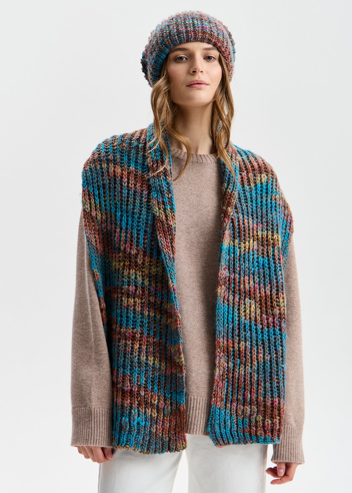 BRIKOLY London Turquoise multicolor knit beanie worn by a model with a matching scarf draped down the front.