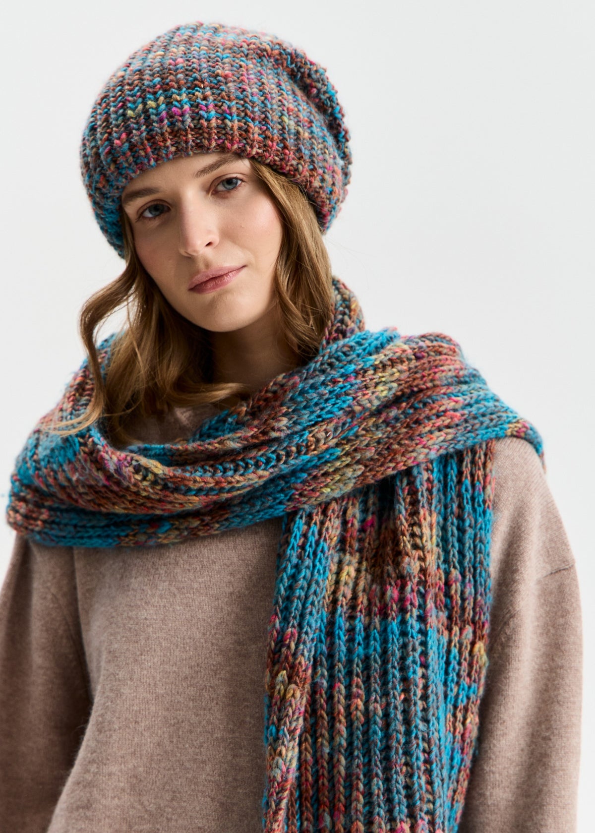 BRIKOLY London Turquoise multicolor knit beanie shown with a matching scarf wrapped around a model's shoulders.