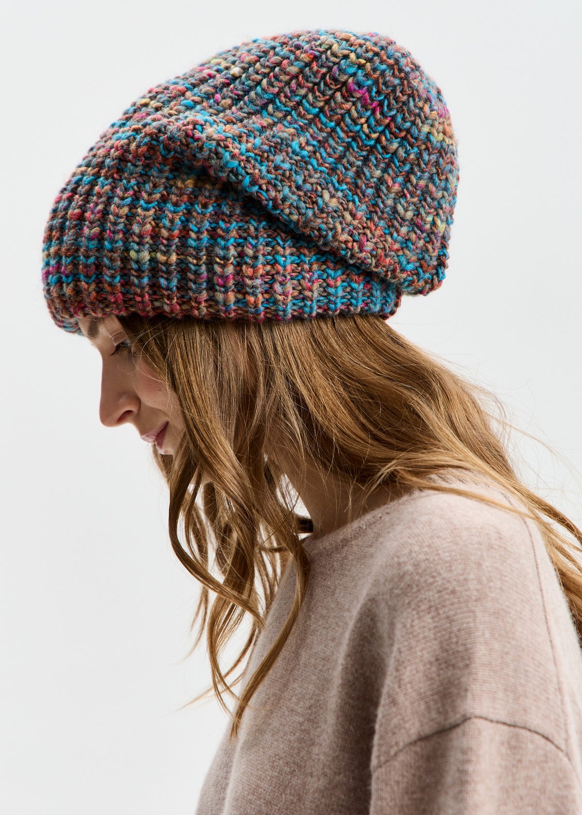 BRIKOLY London Turquoise multicolor knit beanie worn by a model looking down in a side view.