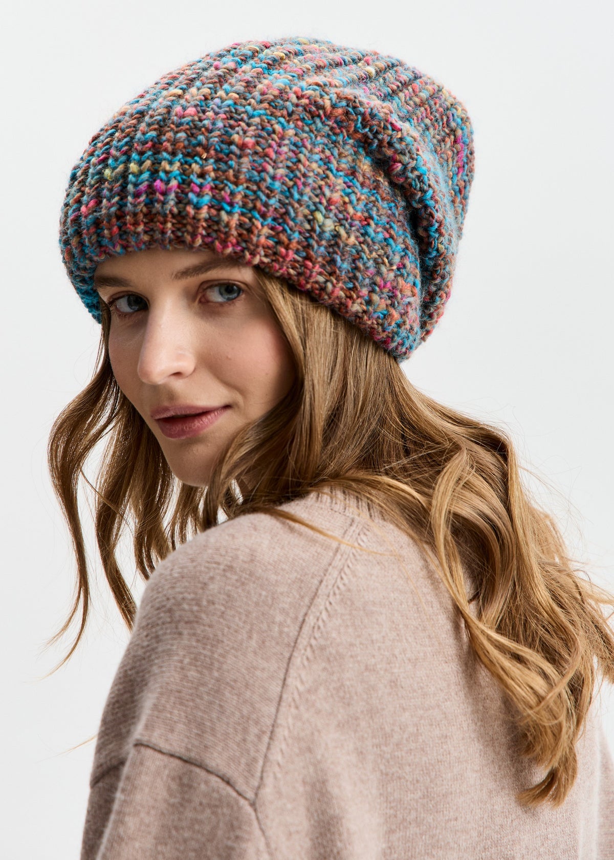 BRIKOLY London Turquoise multicolor knit beanie shown on a model looking back toward the camera.