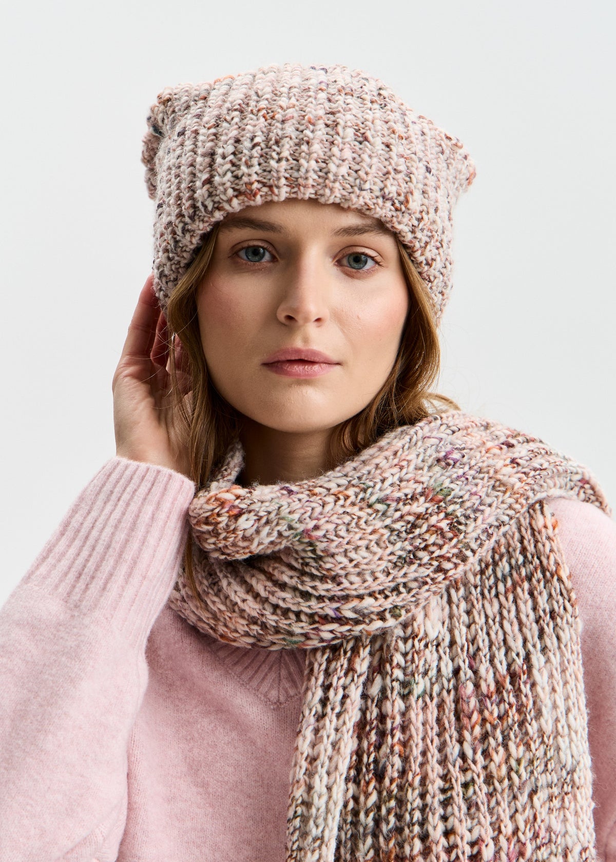 BRIKOLY London Beige multicolor knit beanie worn with a matching scarf as a model touches the brim.
