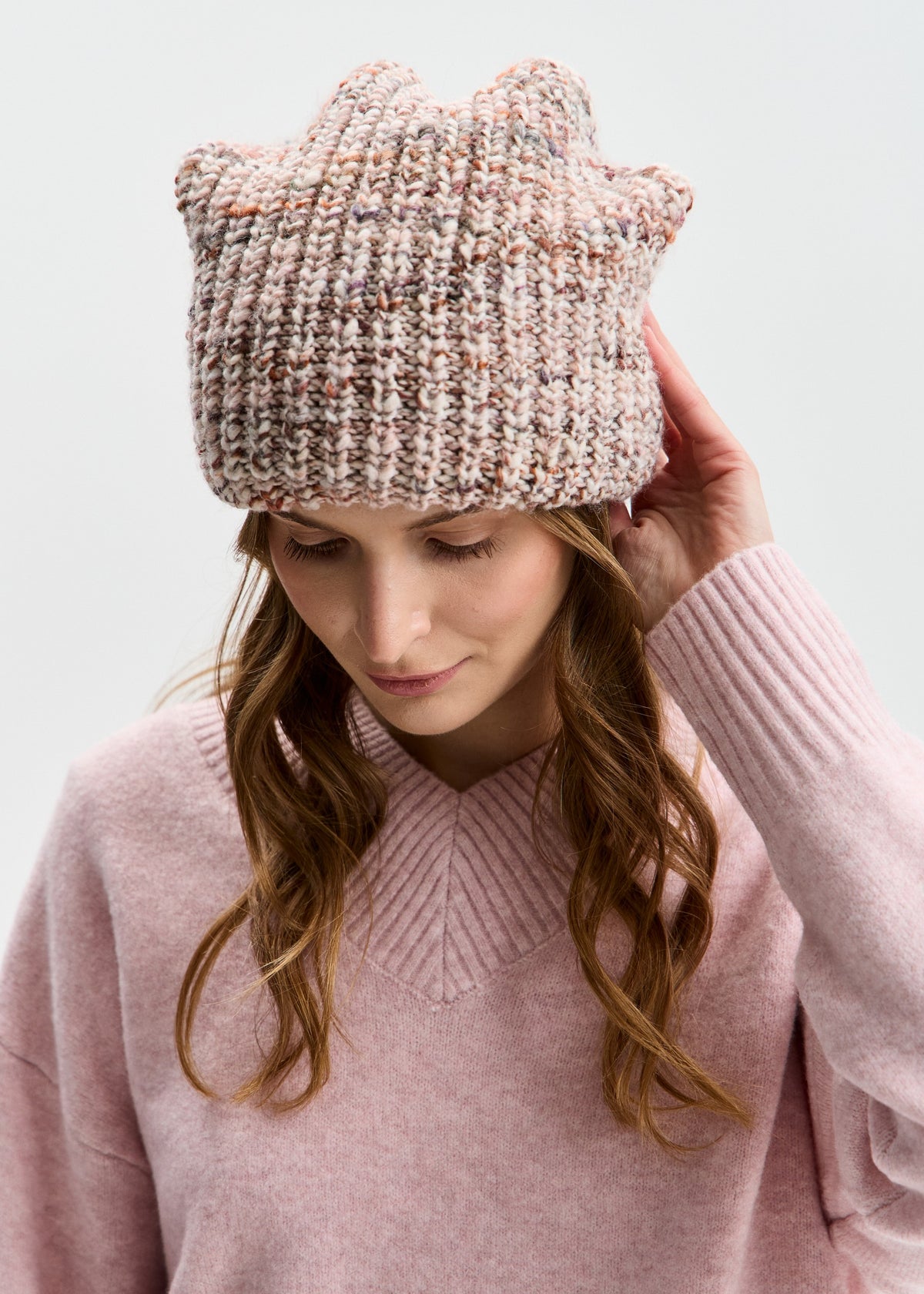 BRIKOLY London Beige multicolor knit beanie worn by a model looking down and touching the brim.