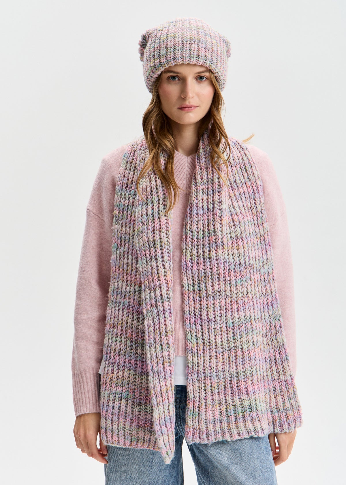 BRIKOLY London Unicorn pastel multicolor knit beanie worn by a model in a full outfit with a matching scarf.