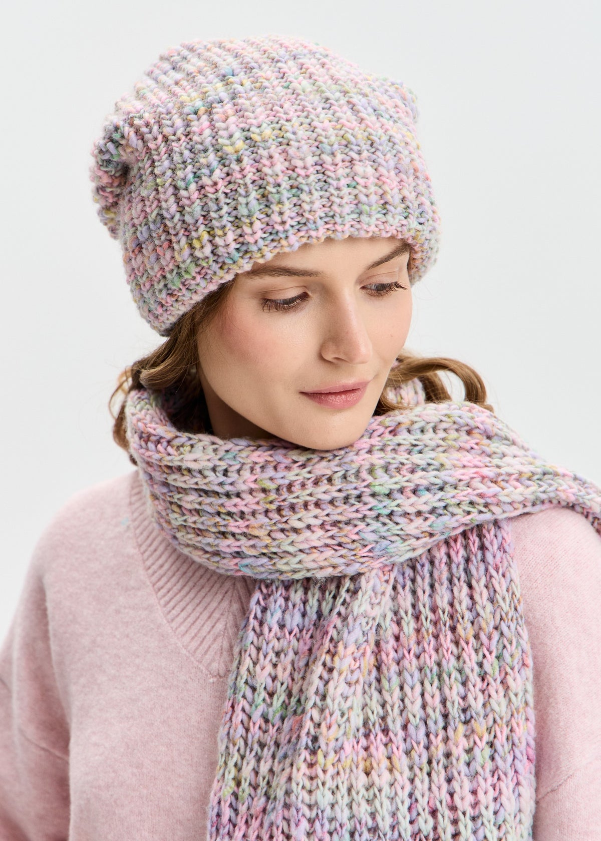BRIKOLY London Unicorn pastel multicolor knit beanie shown on a model looking down with a matching scarf.