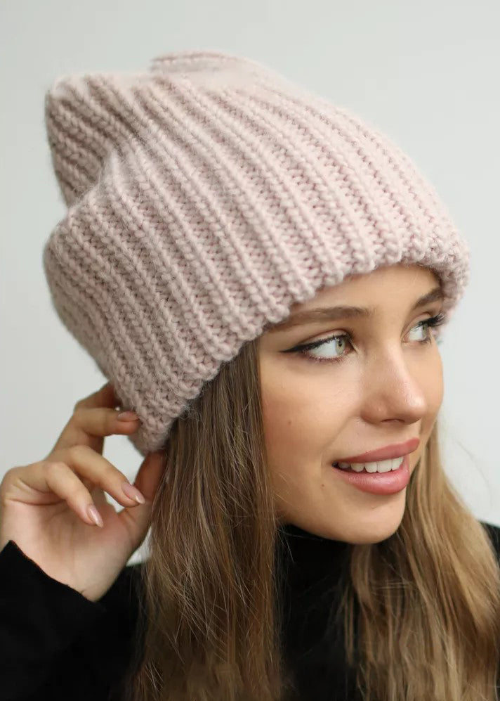BRIKOLY London Pink knit beanie shown close up on a smiling model.