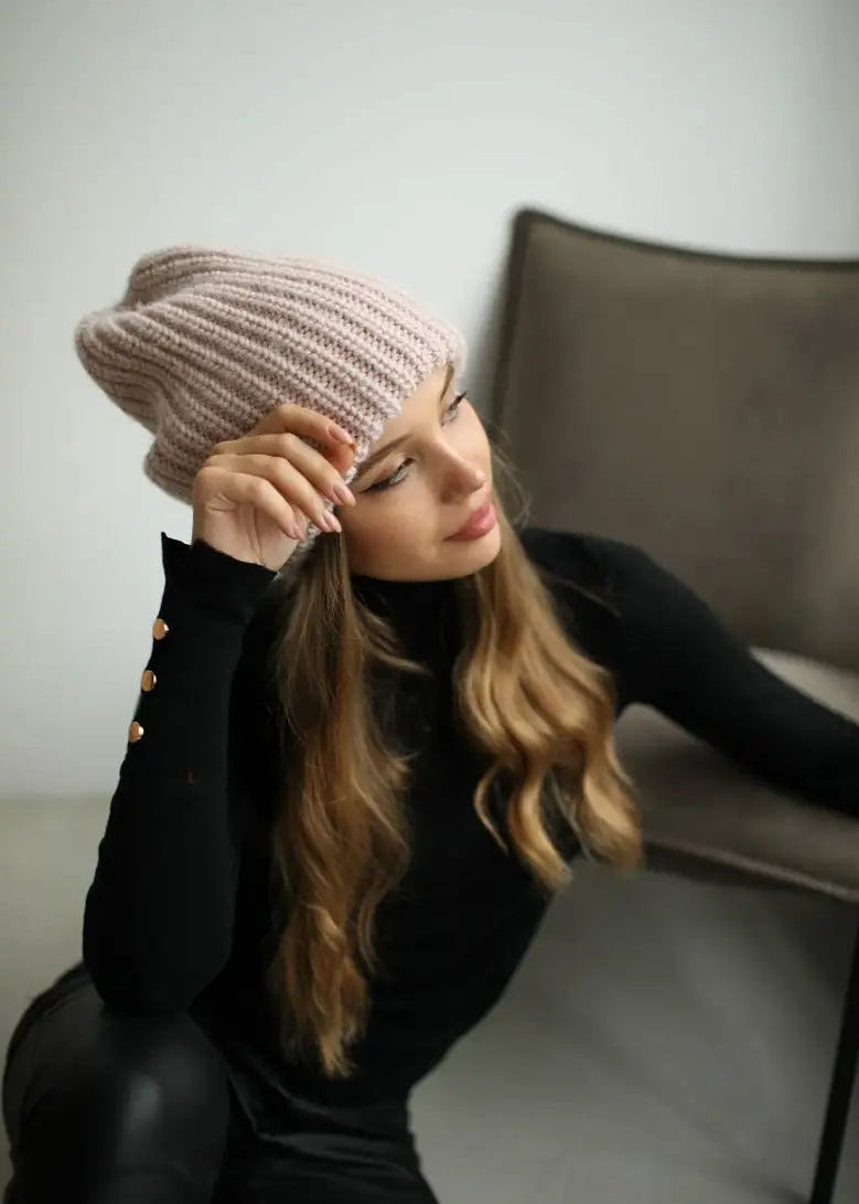 BRIKOLY London Pink knit beanie worn by a model touching the brim.