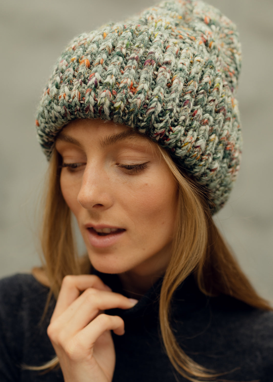 Tokyo Green cable knit wool beanie: Close-up with a hand beside the neck