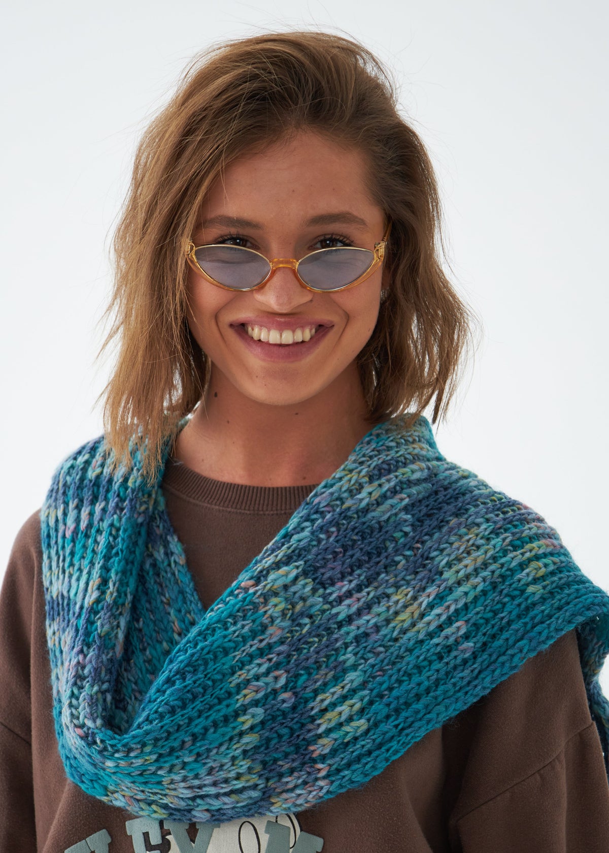 Oversized Tiffany alpaca-wool scarf: Smiling portrait wrapped at the neck; beanie sold separately