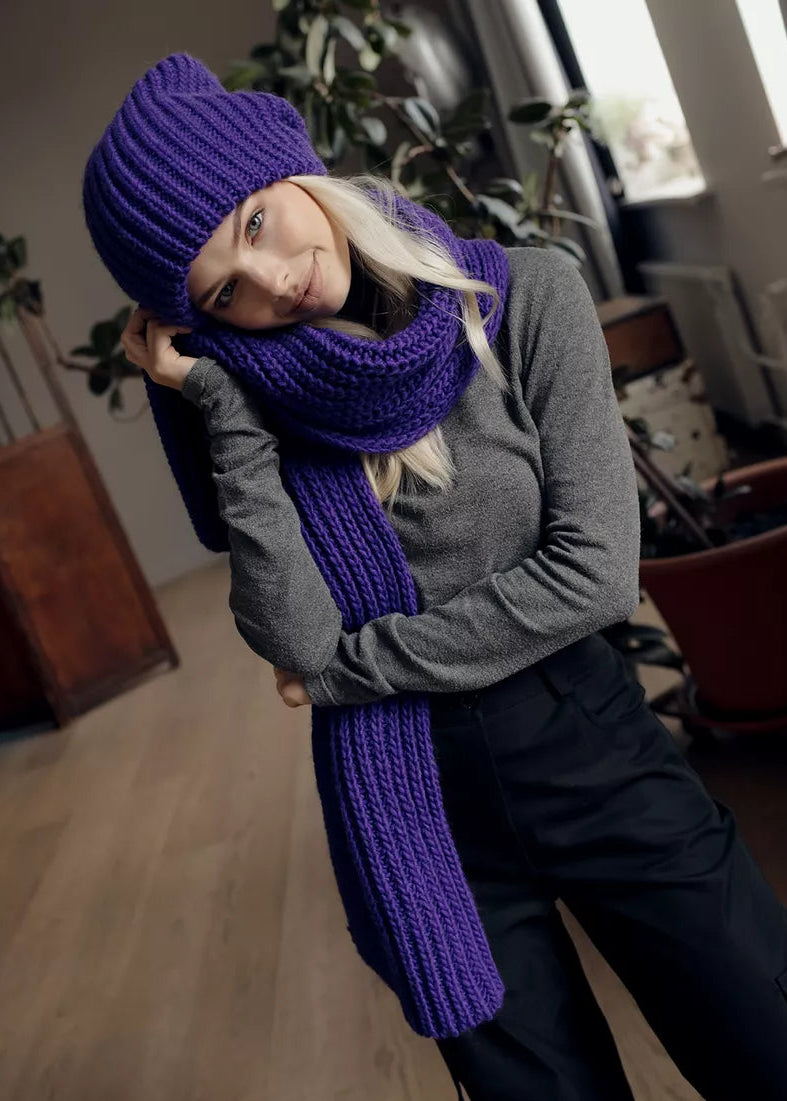 BRIKOLY London Lavender knit beanie worn by a model tilting her head with a matching scarf.