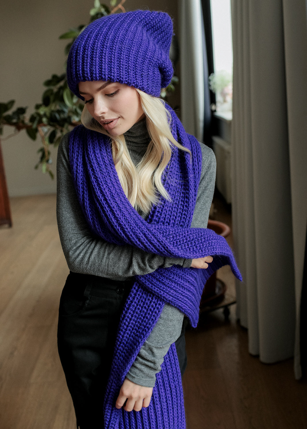 BRIKOLY London Lavender knit beanie shown on a model looking down with a matching scarf.