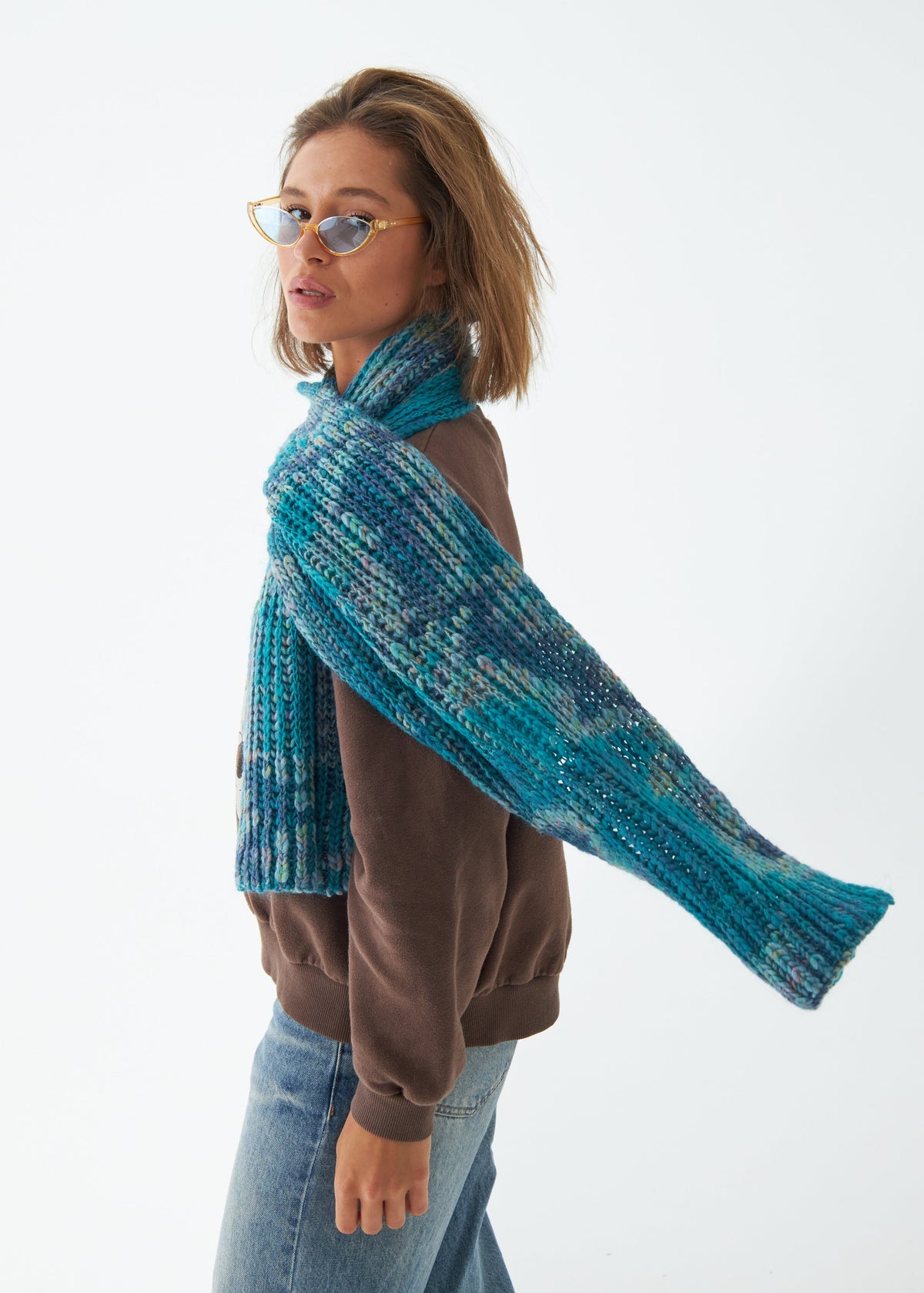 Oversized Tiffany alpaca-wool scarf: Rear three-quarter view holding one end outward; beanie sold separately
