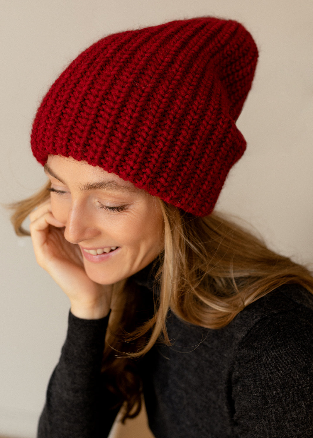 BRIKOLY London Burgundy knit beanie shown on a model touching the side.