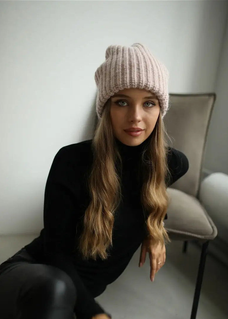 BRIKOLY London Pink knit beanie shown in a front view on a seated model.
