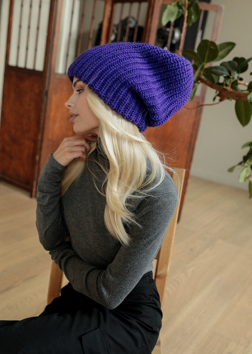 BRIKOLY London Lavender knit beanie shown in profile on a seated model.