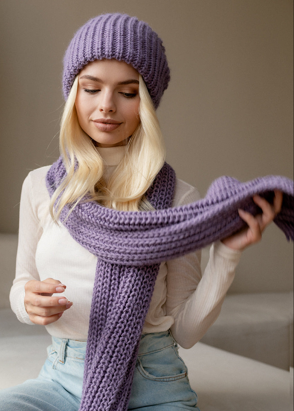Oversized Lilac double-layer wool hat: Seated portrait holding matching scarf, sold separately