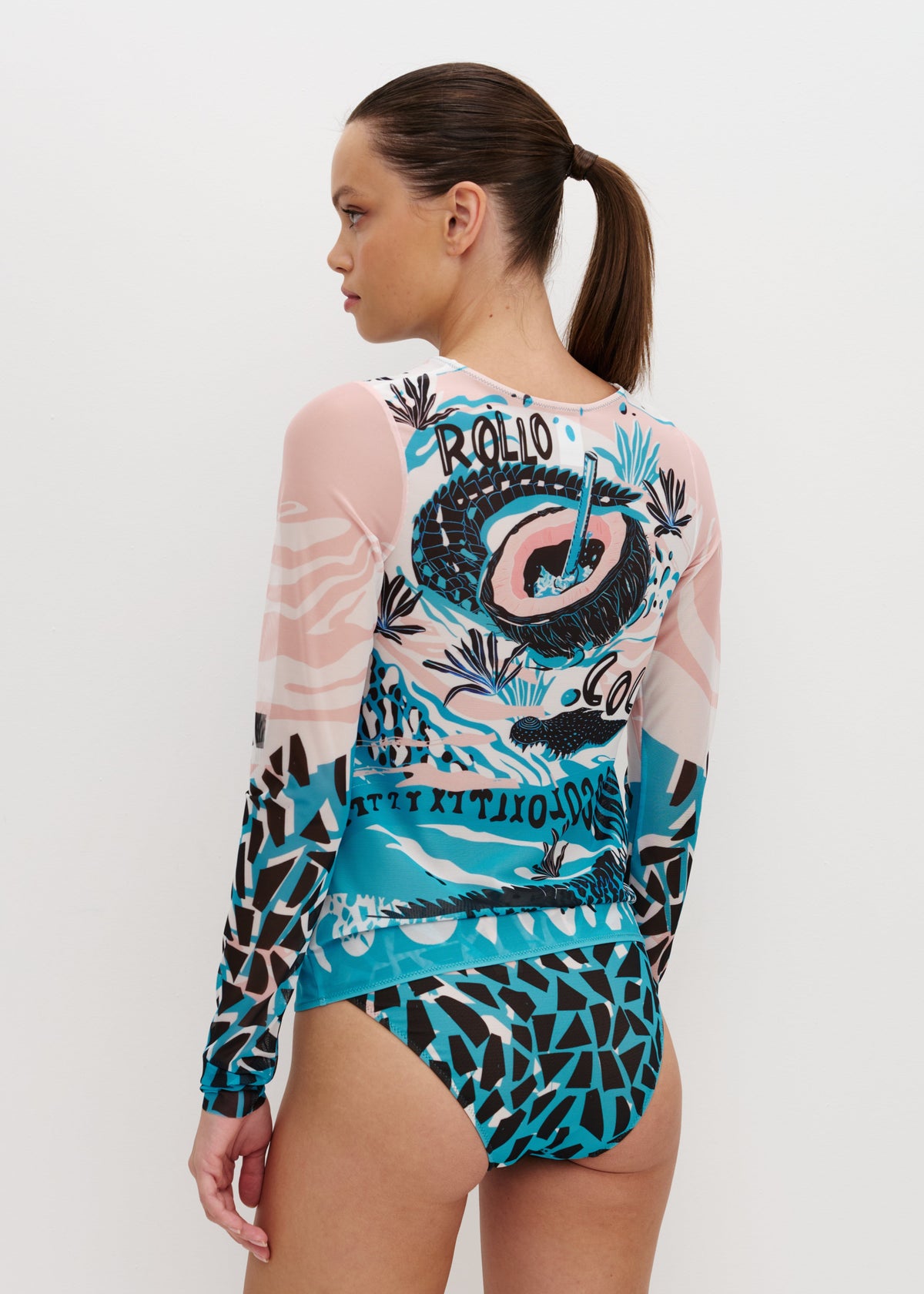 Woman wearing a colorful swimsuit with a brand logo on a white background
