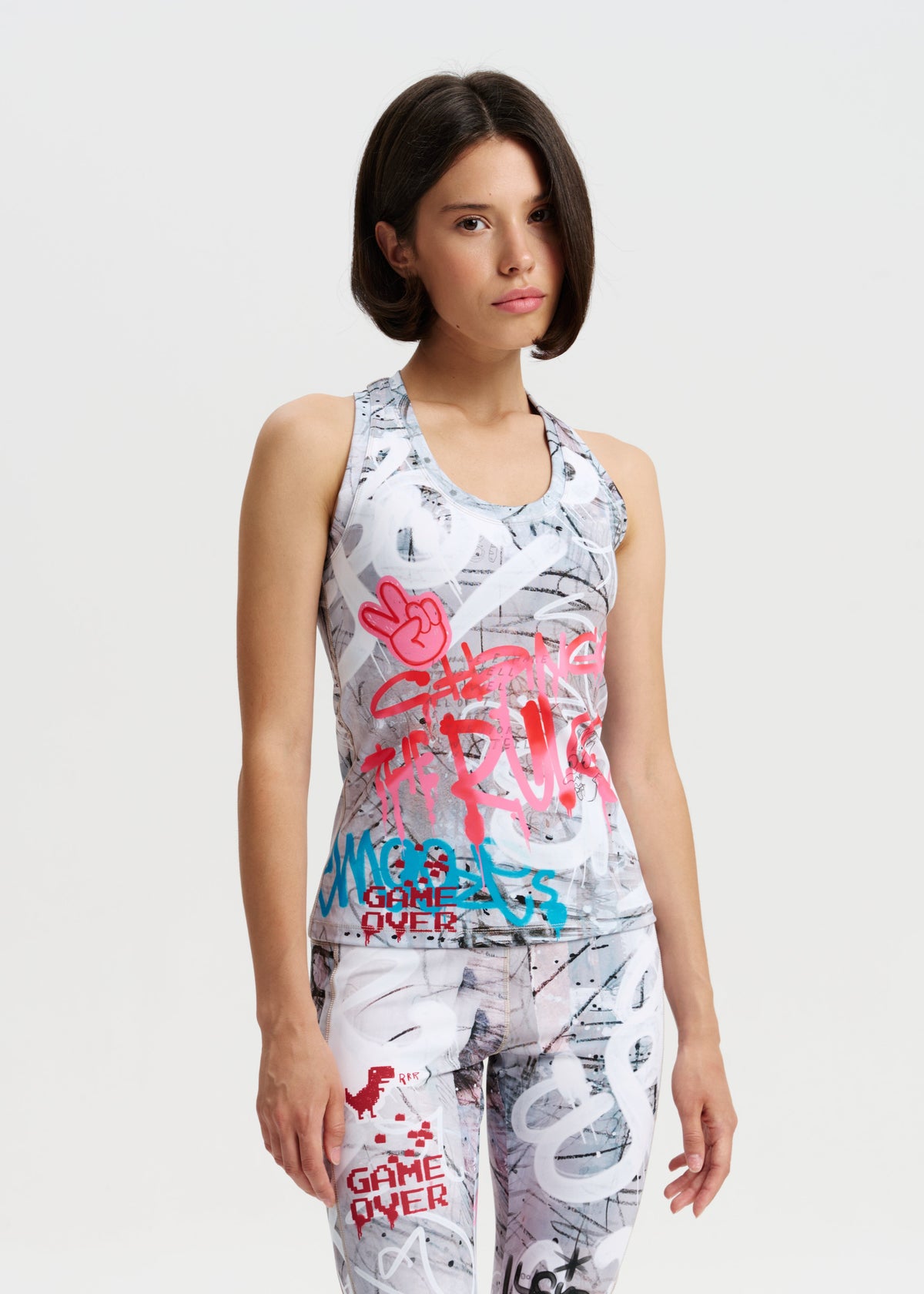 Woman wearing a sleeveless dress with colorful text and graphics on a white background