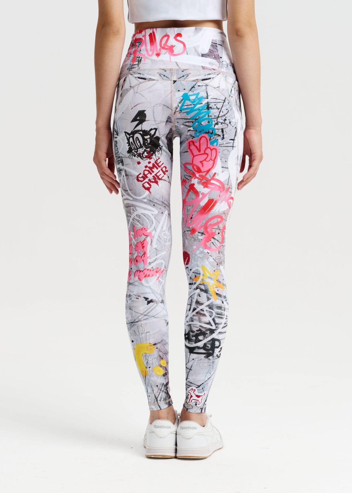 Person wearing colorful graffiti-style leggings on a white background
