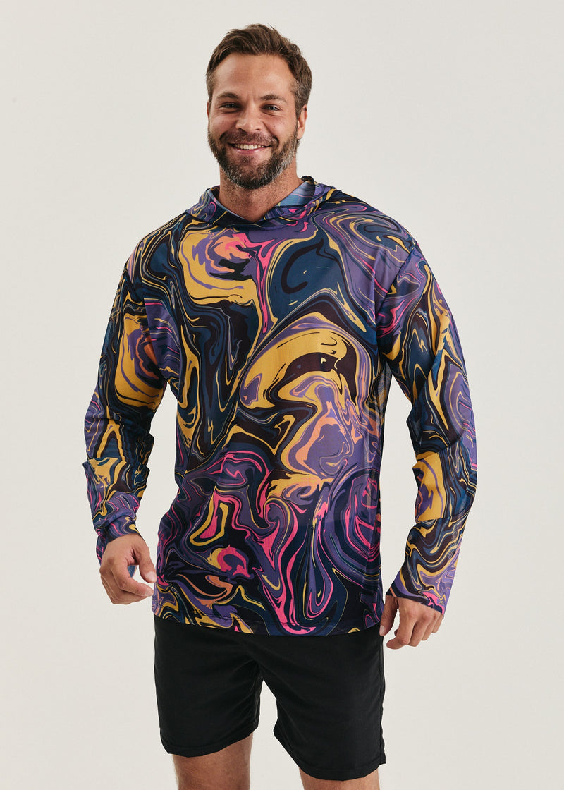 Man wearing a colorful long-sleeve mesh shirt with abstract patterns on a white background