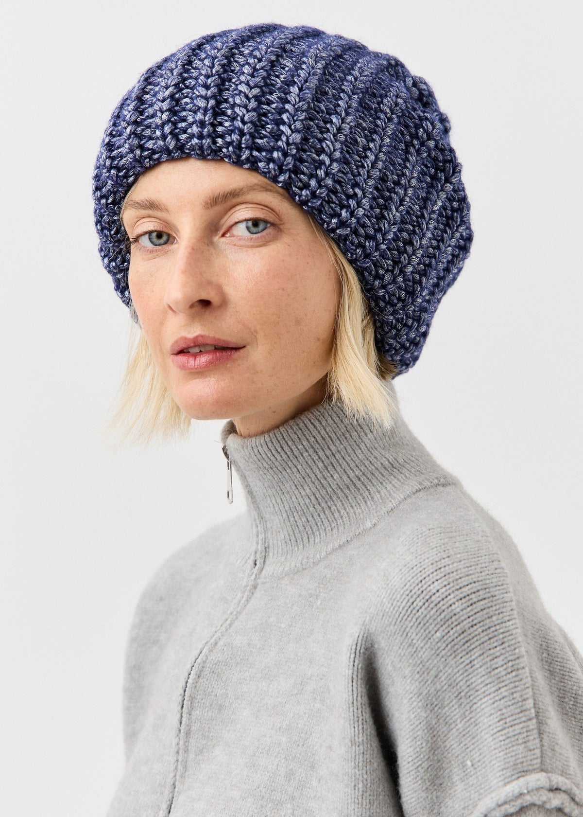BRIKOLY Lustre Denim Melange oversized knit beanie shown on a model facing the camera.