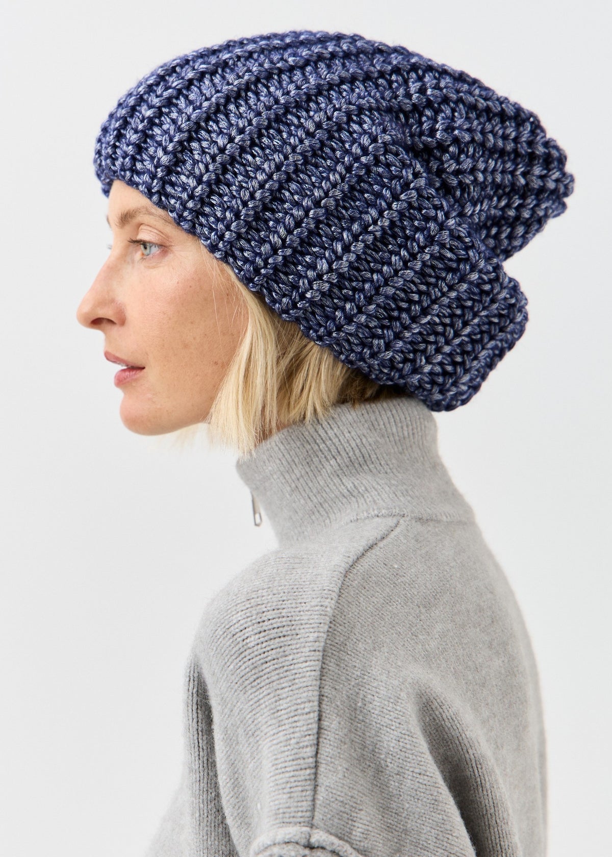 BRIKOLY Lustre Denim Melange oversized knit beanie shown in profile to reveal its slouchy shape.