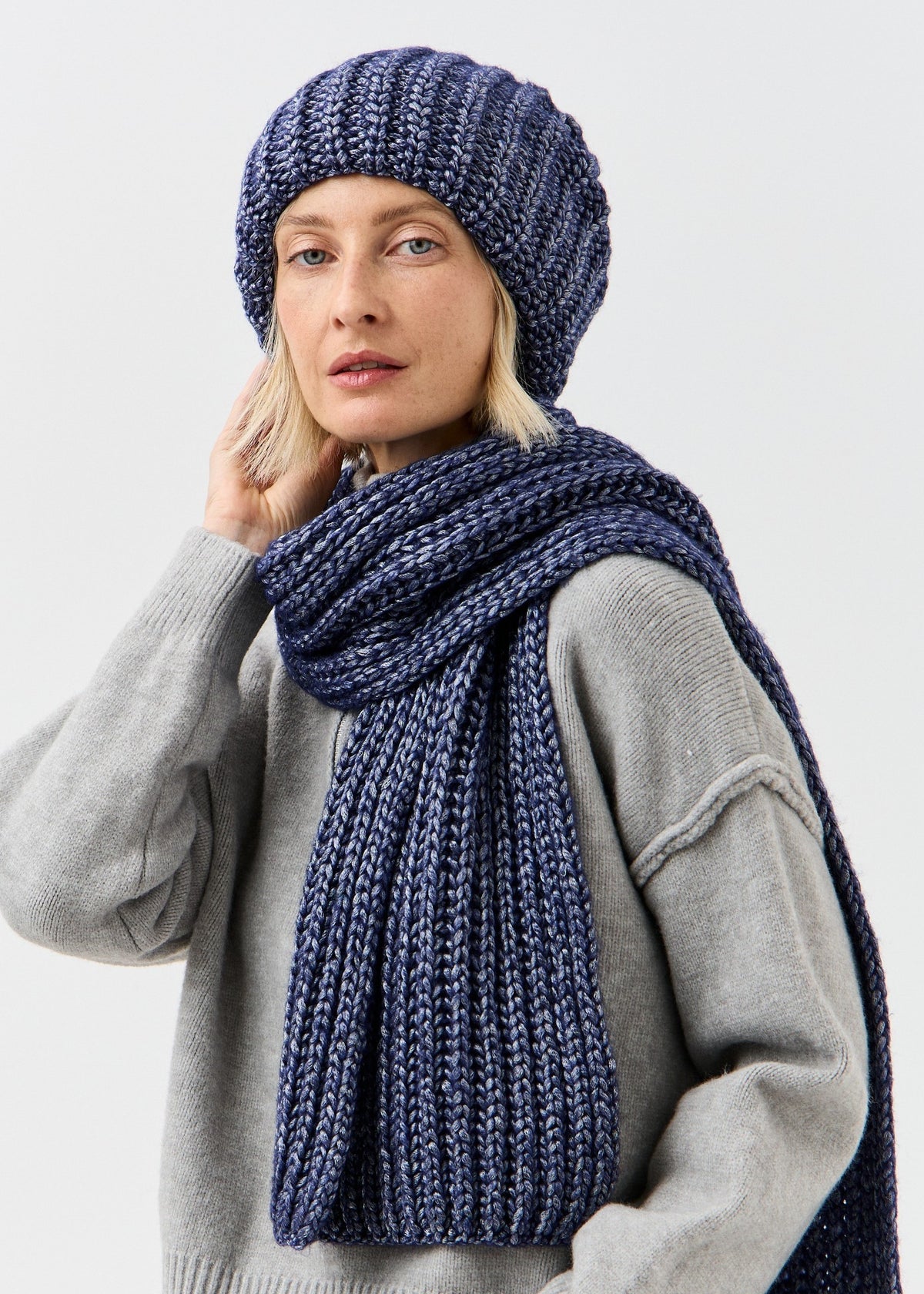 BRIKOLY Lustre Denim Melange oversized knit beanie styled with a matching scarf on a model.