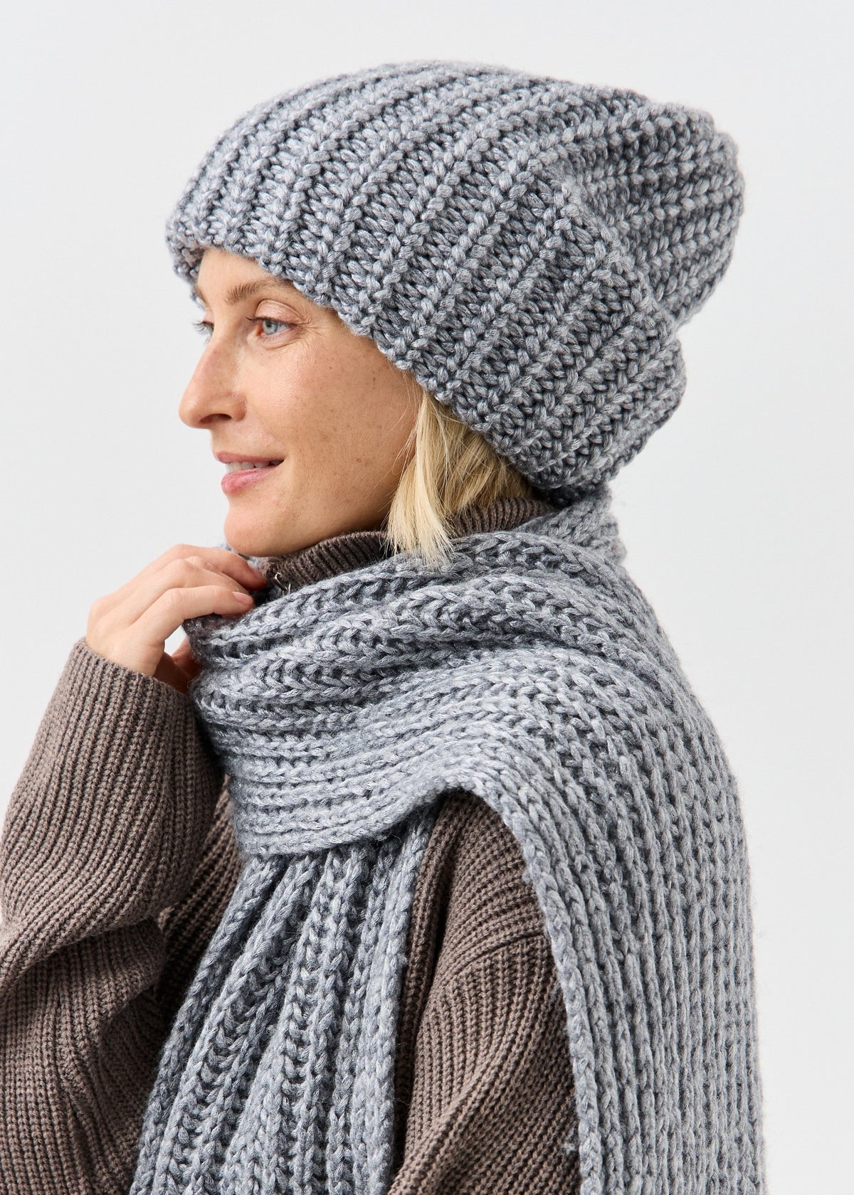 BRIKOLY Lustre Gray Melange knit scarf shown in profile wrapped around a model's neck.