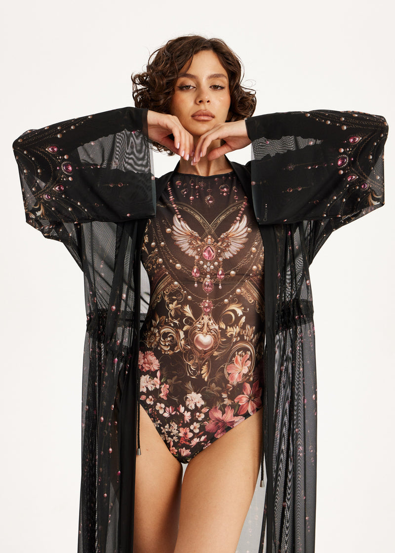 Woman wearing a floral swimsuit with a black cover-up on a white background