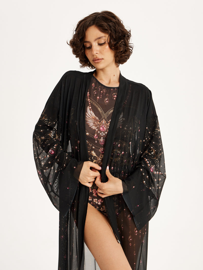 Woman wearing a black kimono-style garment over a patterned outfit on a white background