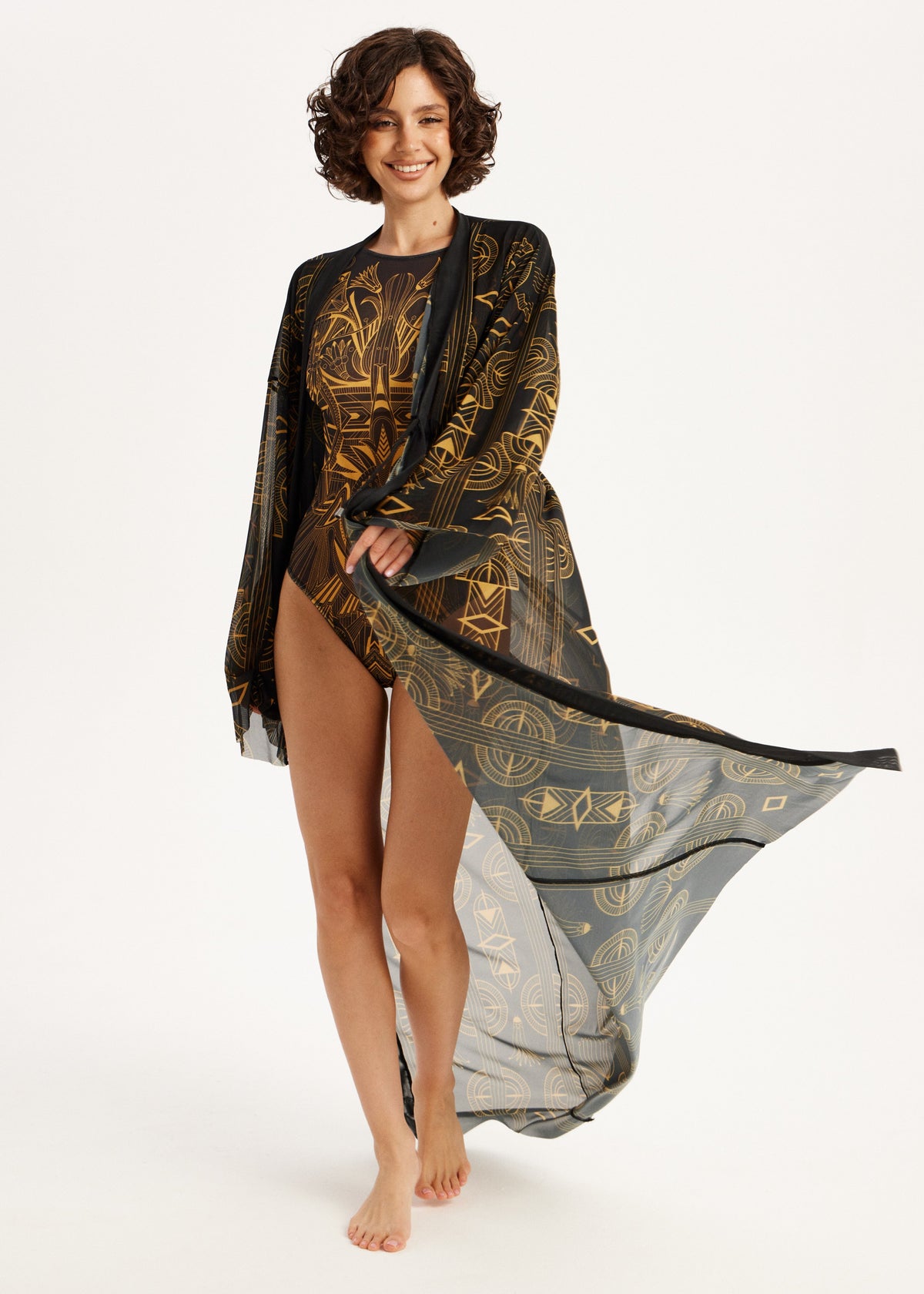 Woman wearing a black and gold patterned sheer swimwear SPF-50 UV-Protection on a white background
