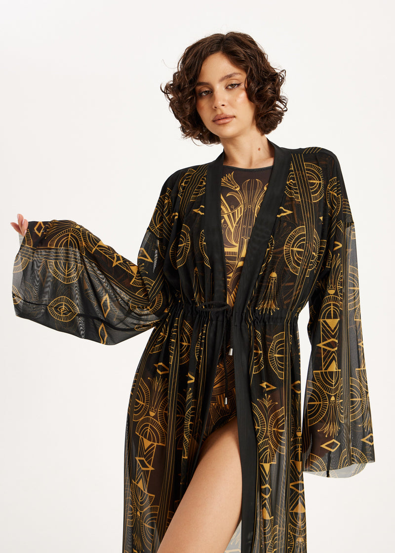 Woman wearing a black and gold patterned swimwear SPF50 UV-protection on a white background