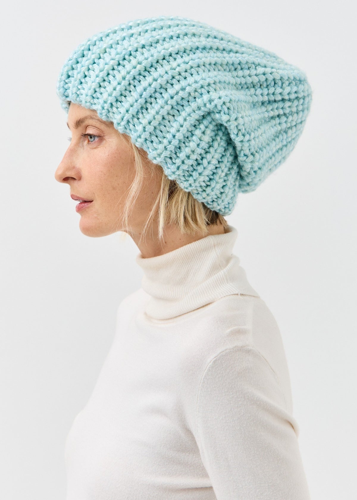 Side profile of the Lustre Blue Melange beanie with a slouchy crown
