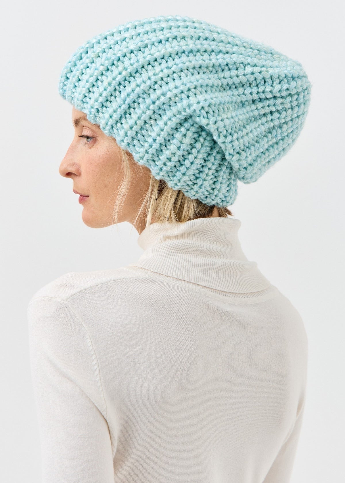 Side view of the Lustre Blue Melange beanie with oversized knit shape