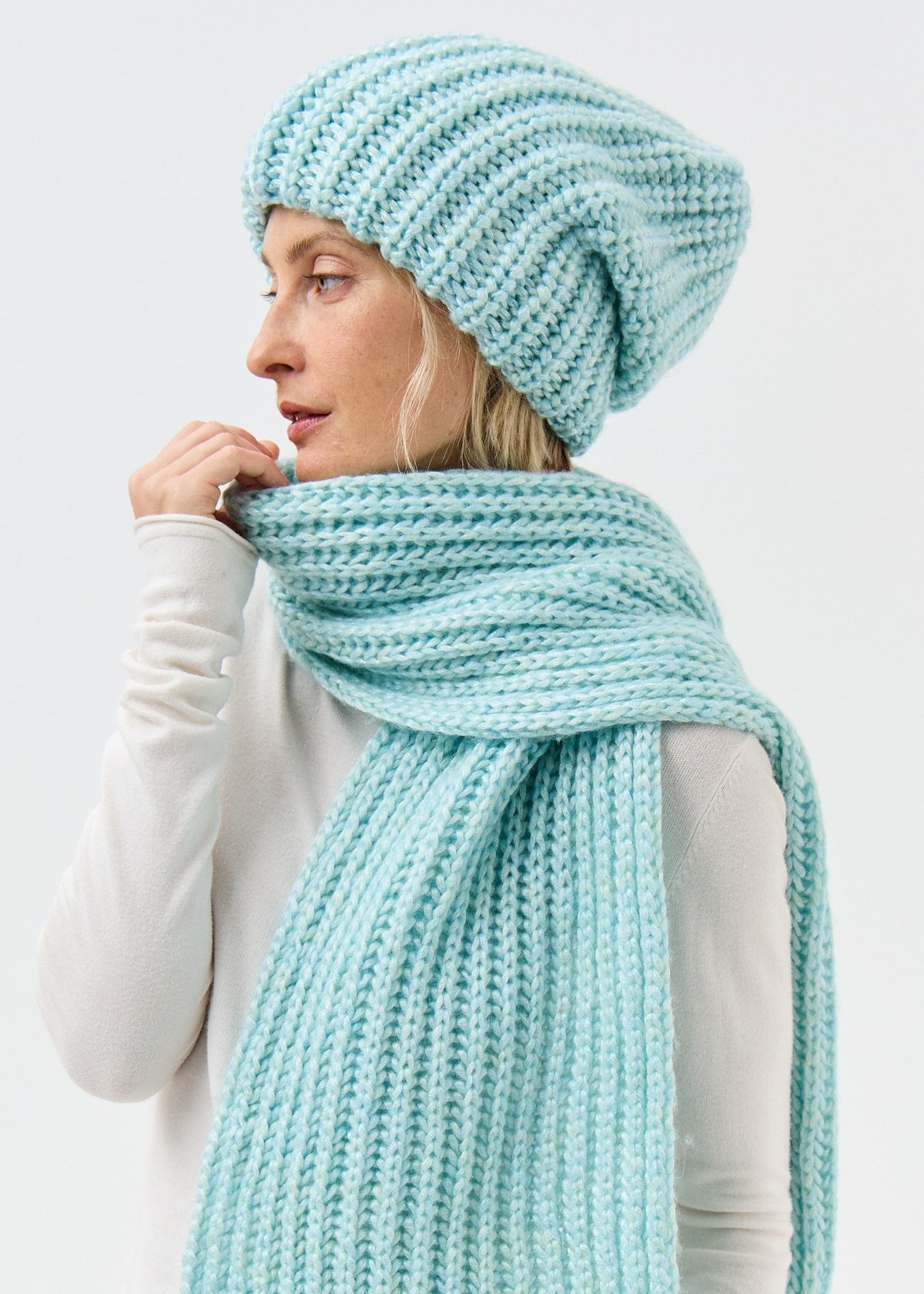 Lustre Blue Melange alpaca-wool scarf: Side close-up with scarf held near the face; beanie sold separately