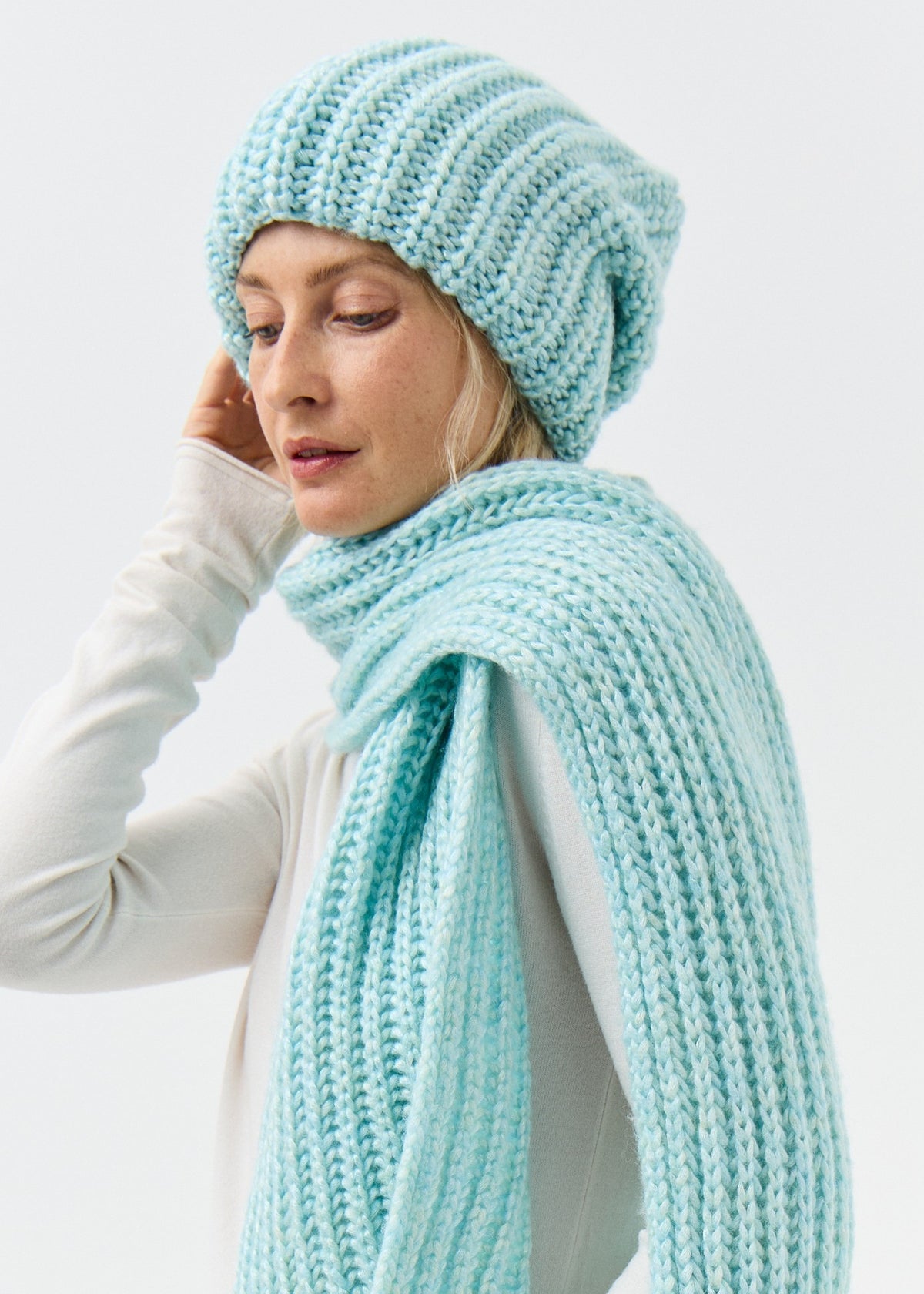 Lustre Blue Melange alpaca-wool scarf: Looking-down close-up wrapped at the neck; beanie sold separately