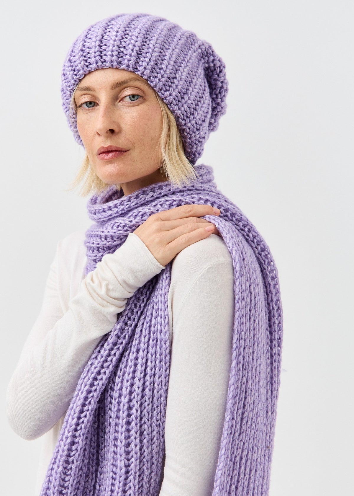 Lustre Violet Melange alpaca-wool scarf: Portrait with a hand resting on the scarf; beanie sold separately