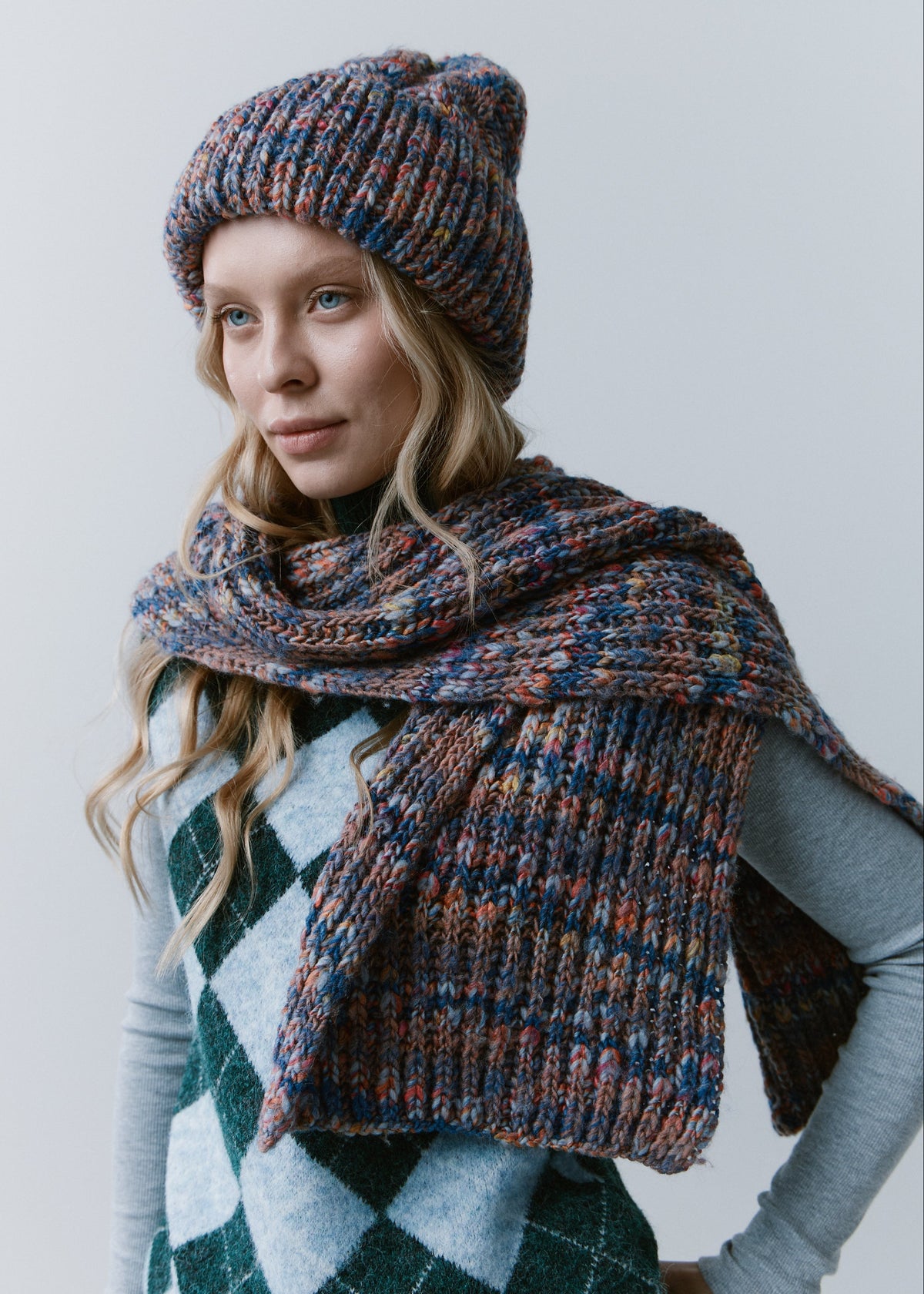 Tokyo Pink and Blue cable knit wool beanie: Three-quarter portrait with matching scarf wrapped at the neck, sold separately
