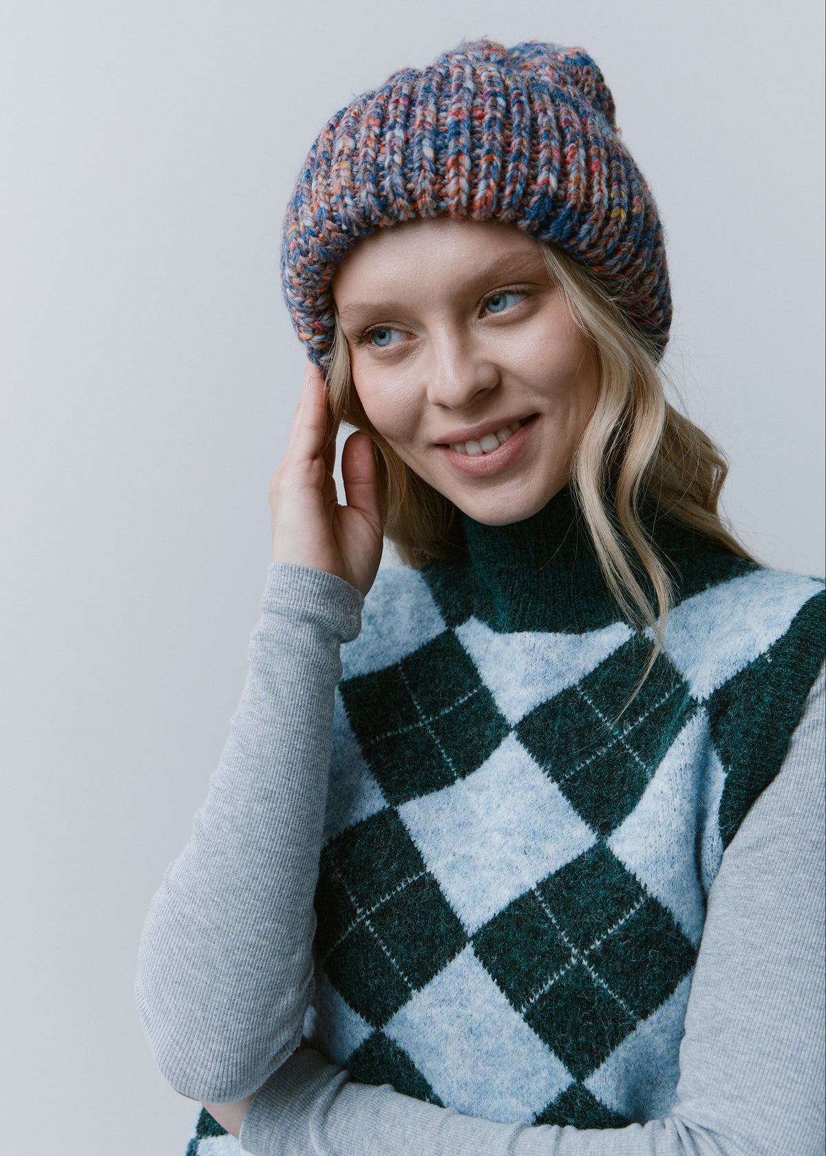 Tokyo Pink and Blue cable knit wool beanie: Three-quarter portrait with a hand at the cuff