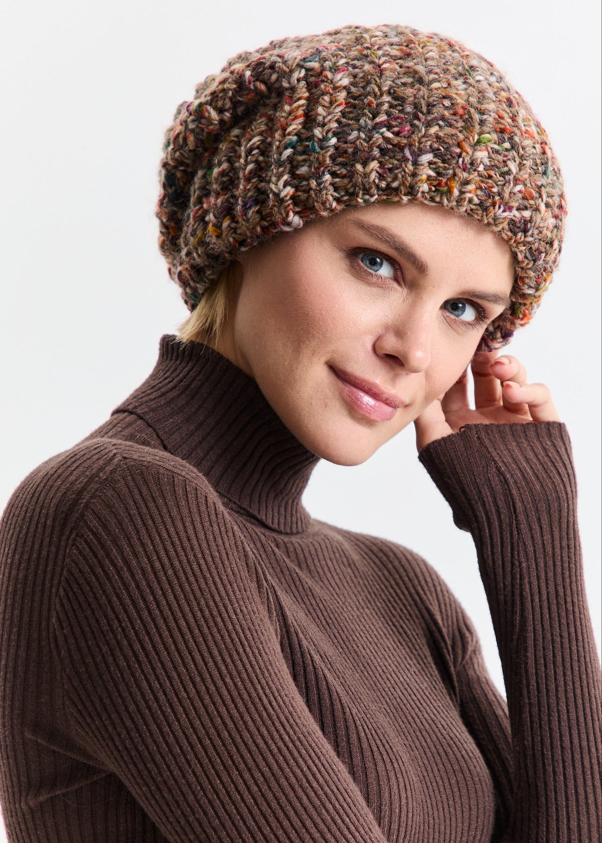 Oversized Multicolor double-layer wool hat: Close-up with a hand beside the face