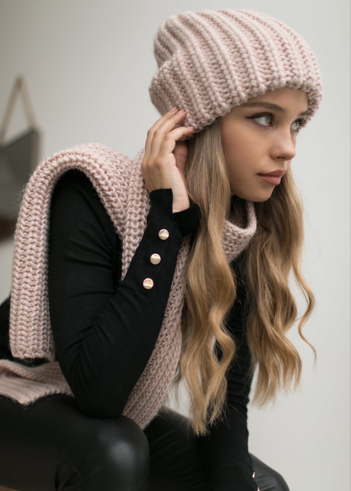 BRIKOLY London Pink knit beanie styled with a matching scarf over a model's shoulder.
