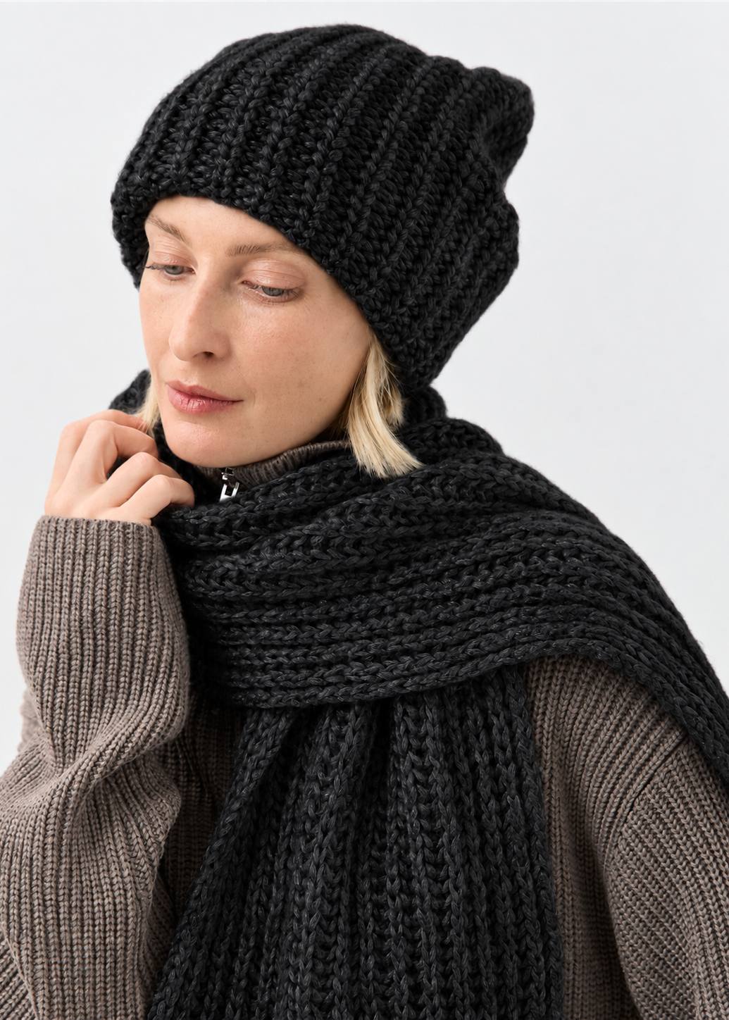 Lustre Black Melange alpaca-wool scarf: Looking-down close-up with a hand at the scarf; beanie sold separately