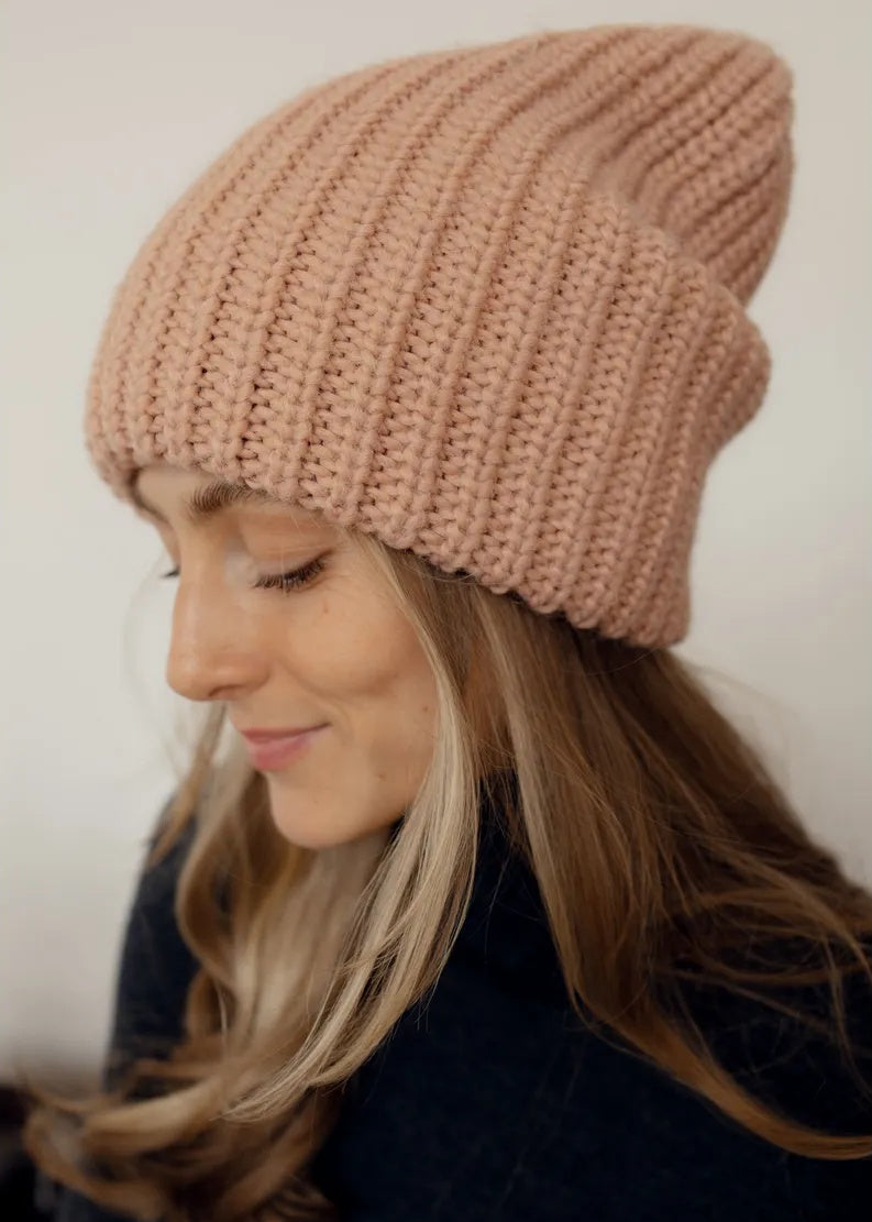 BRIKOLY London Peach knit beanie shown close up on a model looking down.