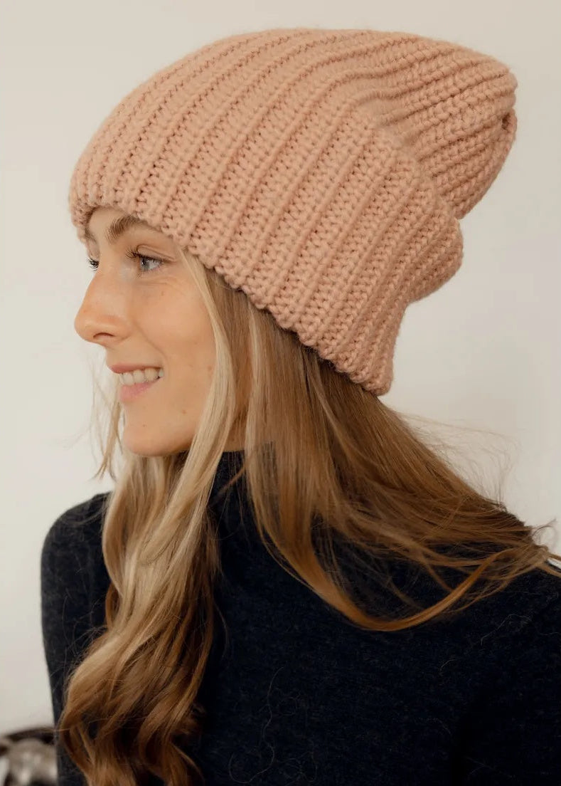 BRIKOLY London Peach knit beanie shown in profile on a smiling model.
