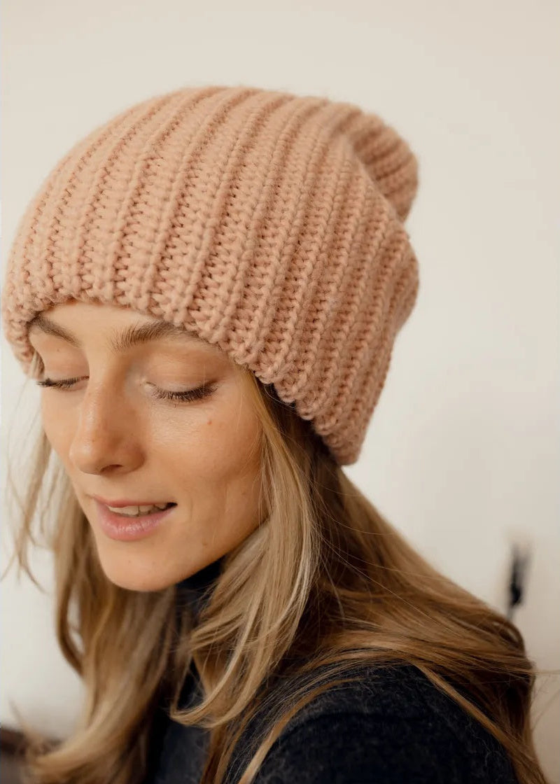 BRIKOLY London Peach knit beanie shown on a model with eyes closed.